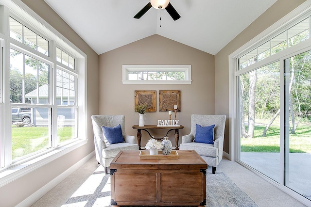 sitting room with ceiling fan, light colored carpet, plenty of natural light, and vaulted ceiling