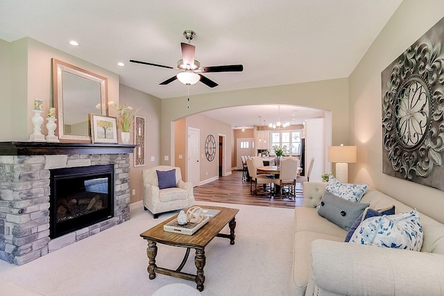 living room featuring wood-type flooring, ceiling fan, and a fireplace