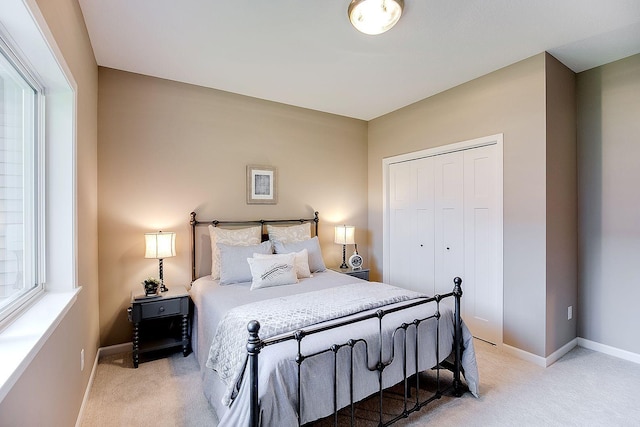 bedroom with light colored carpet and a closet