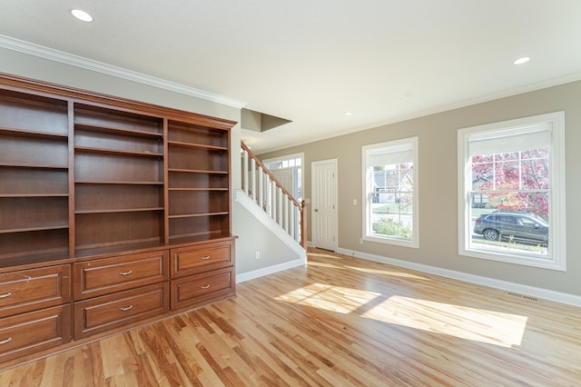 unfurnished living room with ornamental molding and light wood-type flooring