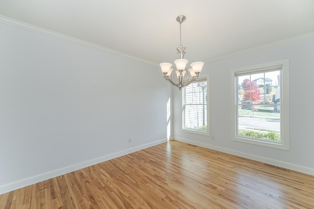 spare room with crown molding, light hardwood / wood-style flooring, and a chandelier