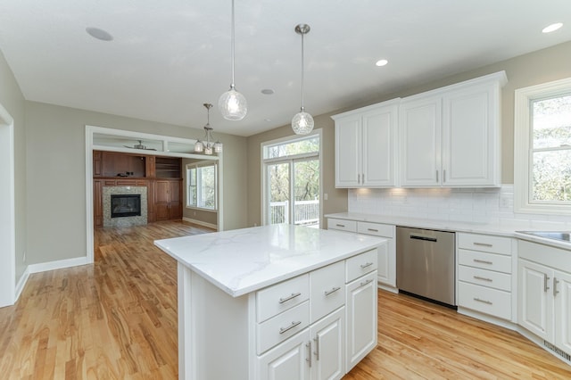 kitchen featuring dishwasher, white cabinets, decorative light fixtures, and plenty of natural light