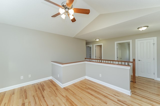 spare room featuring vaulted ceiling, light hardwood / wood-style flooring, and ceiling fan