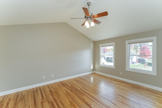 empty room featuring vaulted ceiling, light hardwood / wood-style floors, and ceiling fan