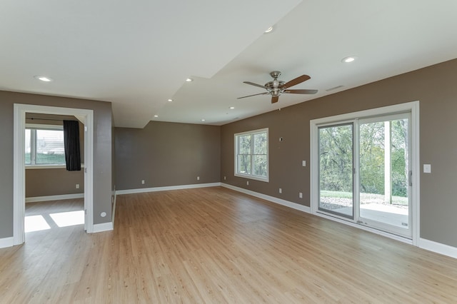 spare room with ceiling fan, light wood-type flooring, and a wealth of natural light