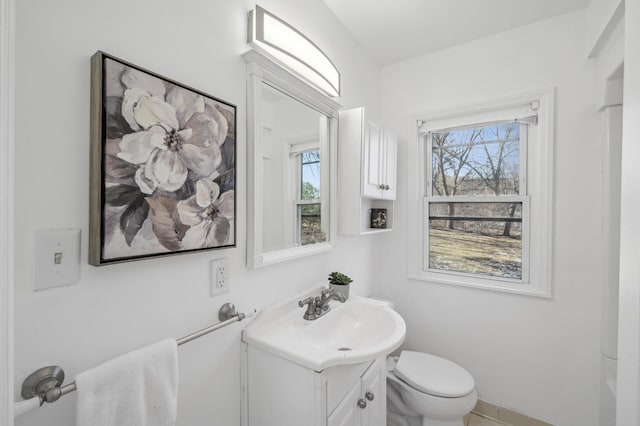 bathroom with vanity, toilet, and a healthy amount of sunlight