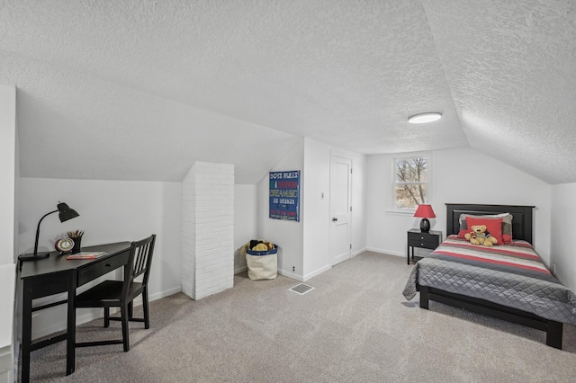 bedroom featuring lofted ceiling, carpet floors, and a textured ceiling