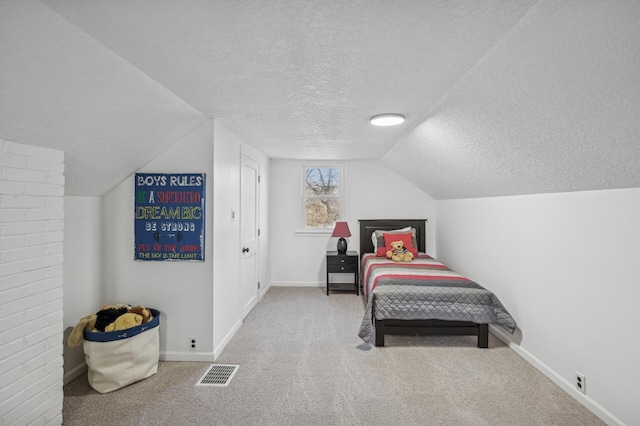 carpeted bedroom featuring lofted ceiling and a textured ceiling