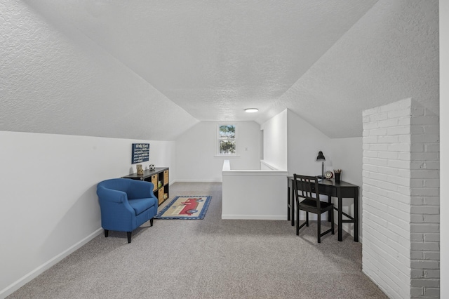 living area with lofted ceiling, carpet flooring, and a textured ceiling