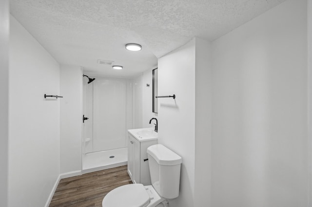 bathroom with walk in shower, toilet, a textured ceiling, vanity, and hardwood / wood-style floors