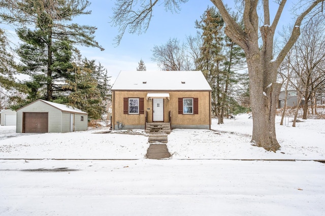 view of front of home with a garage and an outbuilding