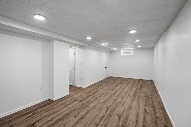 basement with hardwood / wood-style flooring and a textured ceiling