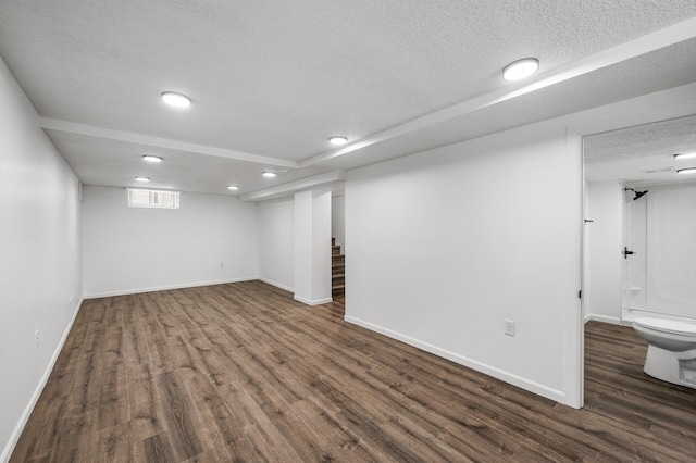 basement featuring dark hardwood / wood-style floors and a textured ceiling