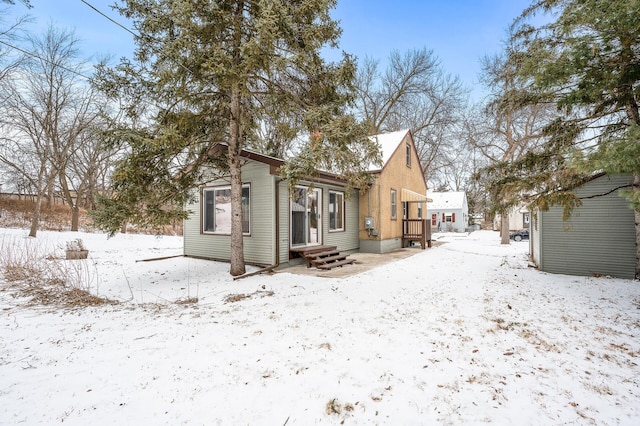 view of snow covered back of property