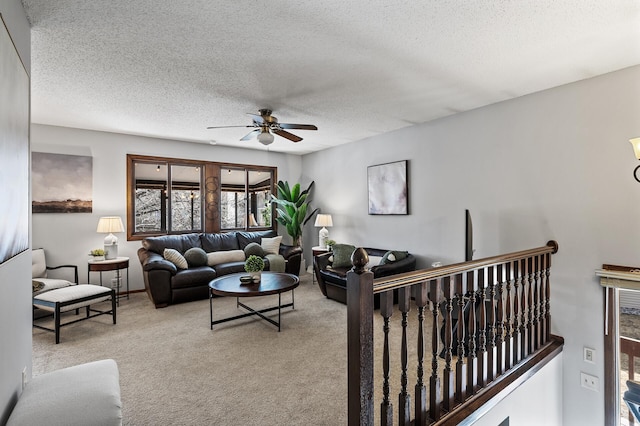 living area featuring a ceiling fan, carpet, and a textured ceiling