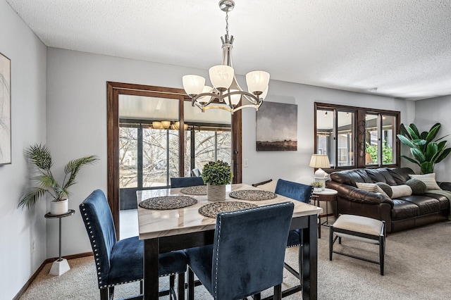 dining area with light colored carpet, a textured ceiling, baseboards, and an inviting chandelier