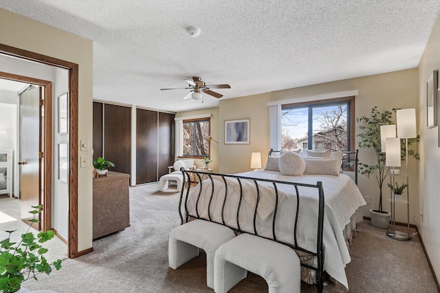 bedroom with a textured ceiling, multiple windows, and light colored carpet