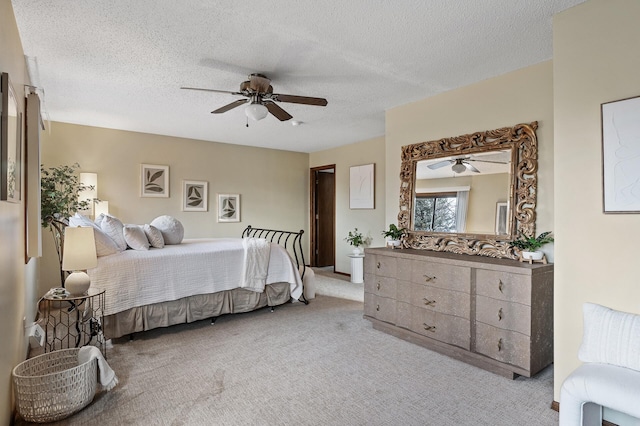 bedroom featuring a ceiling fan, light colored carpet, and a textured ceiling