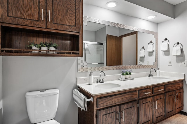 full bathroom with toilet, a stall shower, double vanity, and a sink