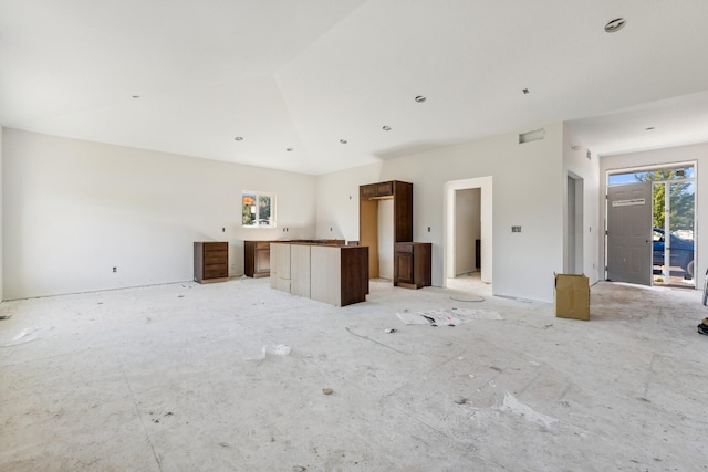 unfurnished living room featuring lofted ceiling