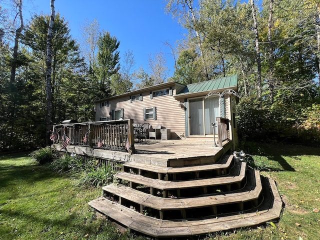 back of property with a wooden deck and a yard