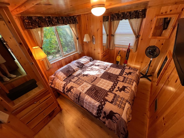 bedroom featuring wooden walls and hardwood / wood-style floors