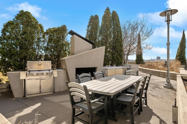 view of patio featuring exterior fireplace and area for grilling