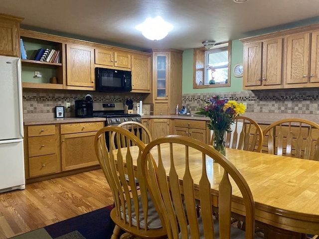 kitchen featuring light wood-type flooring, backsplash, and white refrigerator