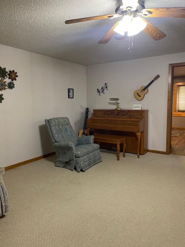 sitting room featuring a textured ceiling, carpet flooring, and ceiling fan