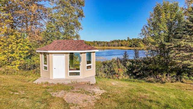 view of outdoor structure featuring a water view and a yard