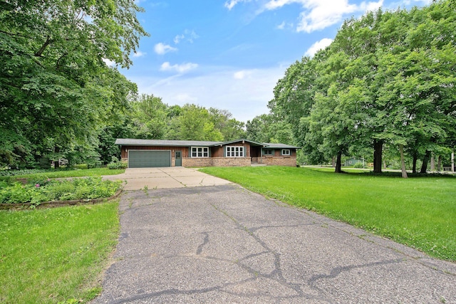 ranch-style house featuring a garage and a front lawn