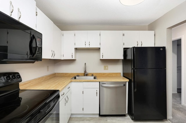 kitchen featuring white cabinets, black appliances, sink, and a textured ceiling