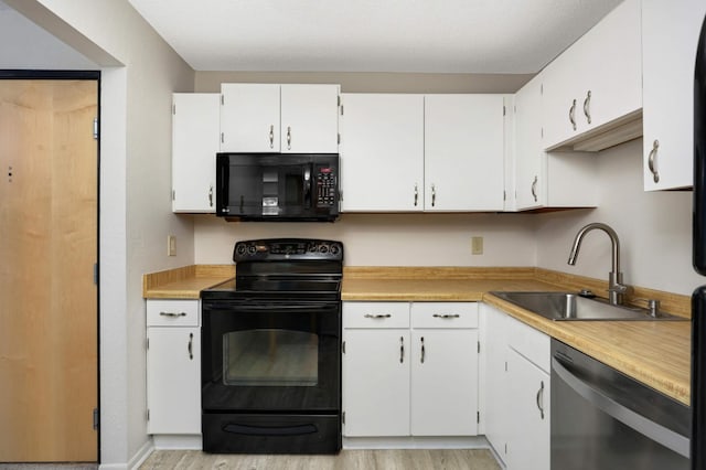 kitchen featuring light hardwood / wood-style floors, white cabinetry, black appliances, and sink