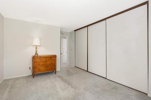 bedroom featuring light carpet and a closet