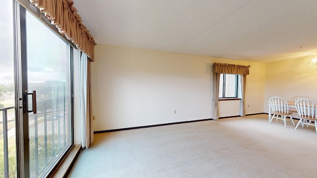 empty room featuring a textured ceiling and light carpet