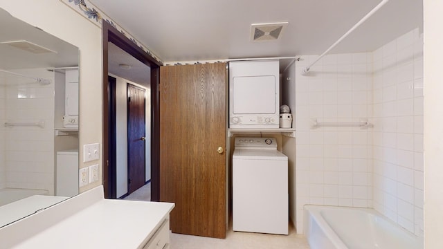 clothes washing area featuring stacked washing maching and dryer