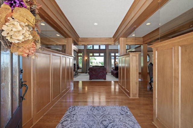 entryway with ornamental molding and hardwood / wood-style floors