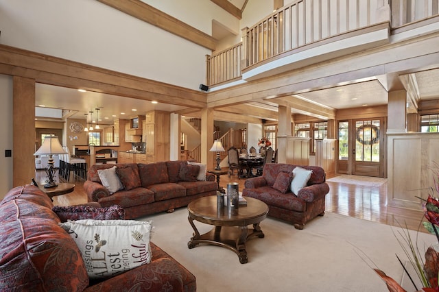 carpeted living room with beam ceiling and a high ceiling