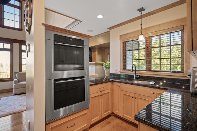 kitchen featuring light hardwood / wood-style floors, double oven, decorative light fixtures, and sink