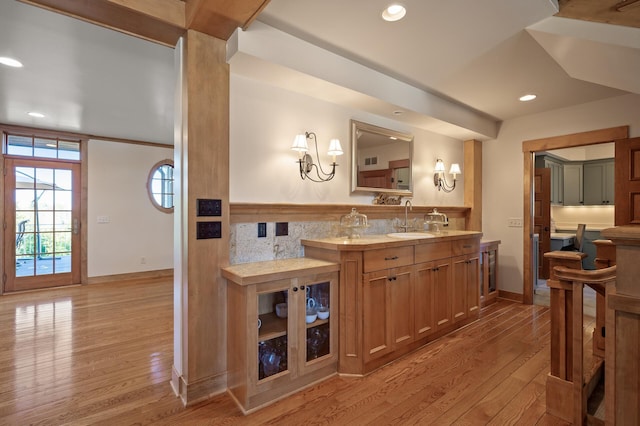 bar featuring light wood-type flooring and sink