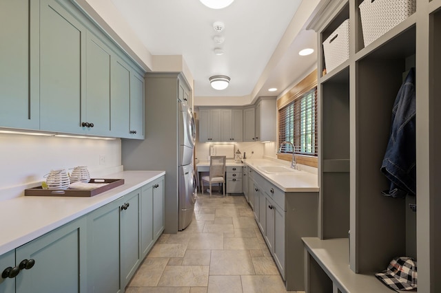 kitchen featuring stacked washer and clothes dryer and sink