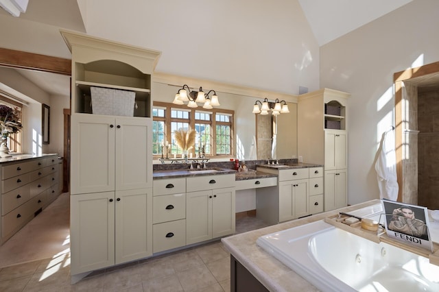 bathroom featuring tile patterned flooring, a chandelier, tiled tub, high vaulted ceiling, and vanity