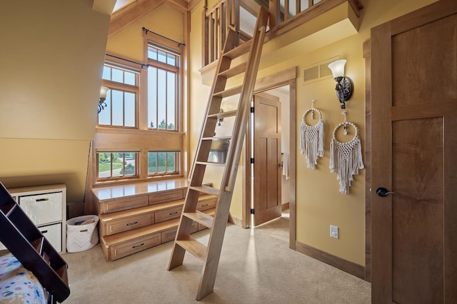 interior space with light carpet and a high ceiling