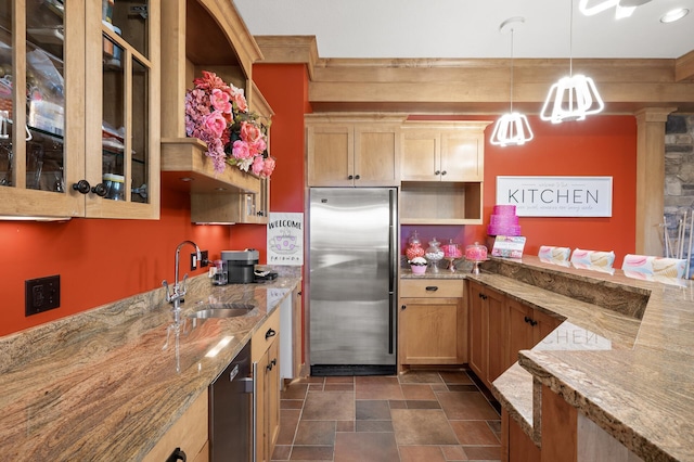 kitchen with light stone countertops, decorative light fixtures, sink, and stainless steel appliances