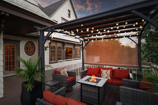 deck at dusk with an outdoor living space with a fire pit