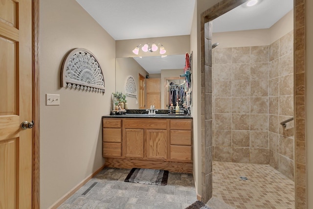 bathroom featuring tiled shower and vanity