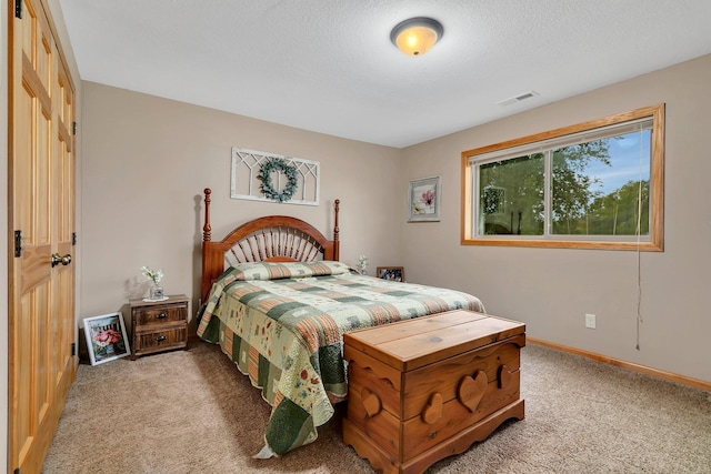 bedroom featuring a textured ceiling and light colored carpet