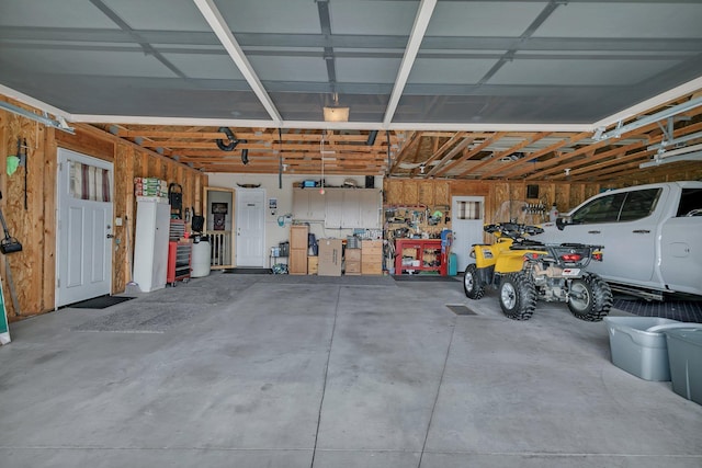 garage with wood walls and a workshop area