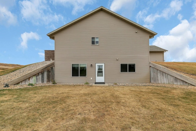 rear view of house featuring a yard