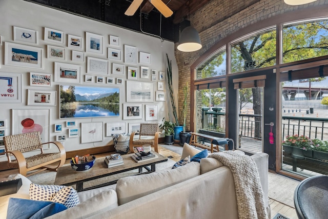 living room featuring wood-type flooring, a towering ceiling, and ceiling fan